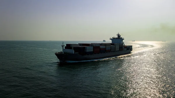 cargo container ship carrying in sea import export goods and distributing products to dealer consumers across Asia pacific and worldwide global business transportation by container ship open sea aerial front vie