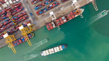 Ticari nakliye portu yükü ve konteynır gemisinden kargo boşaltma müşterilere ve satıcılara taşınan römorklarla mal dağıtmak için vinçle ithalat ihracat.