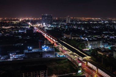 Samut Prakan 'da gece saatlerinde uzun pozlu şehir manzarası ve elektrik tren istasyonları çekildi.,
