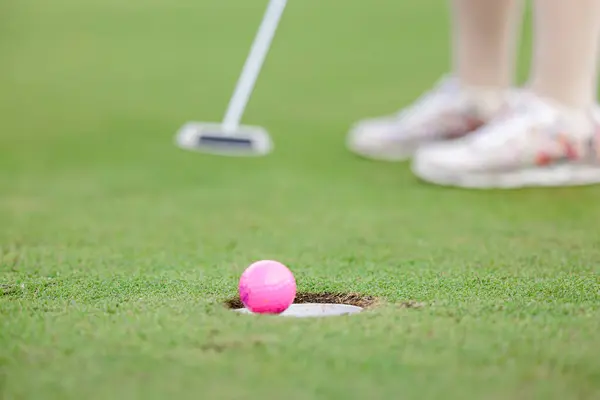 Professional woman golfer teeing golf in golf tournament competition at golf course, selective focus on golf ball,