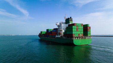 Geniş açı, kargo konteynır gemisinin deniz mavisi arka planda yelken açarak ihracat malları ve dağıtım ürünlerini konteynır gemisi taşımacılığı ve sanayi taşımacılığı hizmetleriyle dünya çapında satıcılara ve tüketicilere ihraç etmek ve dağıtmak için dikey görüntüsünü çekti., 