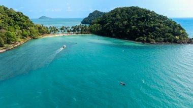 Travel vacation healthy lifestyle Concept. small happy tourist enjoy kayaking in sea on summer vacation at koh chang, trat province, thailand, aerial view from drone, 