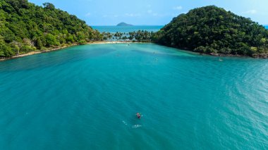 Travel vacation healthy lifestyle Concept. small happy tourist enjoy kayaking in sea on summer vacation at koh chang, trat province, thailand, aerial view from drone, 