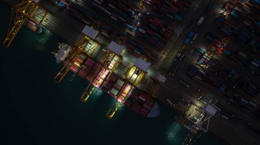 Ticari limanın yukarısından çekilen gece görüntüleri konteynır gemisi ithalat ve ihracatından kargo indirip müşterilere ve satıcılara mal dağıtımı için vinçle ihraç ediliyor.
