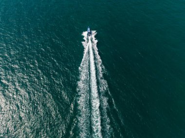 Yeşil denizde uçan sürat teknesi, hava manzaralı.