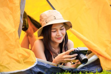 Safari elbiseli ve elinde kamera olan Asyalı genç bir turist sabah vakti çadırın içinde uzanıyordu.