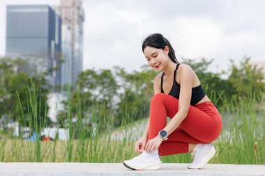 Kadın ayakkabı bağcıklarını şehir merkezindeki parktaki köprüye bağlıyor..