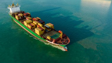 Korgo gemisi konteynırı ve denizde gölge yansıması. Deniz piyadelerine ve tüketicilere bir ulaşım ve dağıtım sistemidir. İnsansız hava aracı bakış açısı