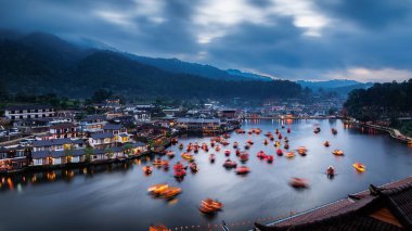 Geleneksel Çin tarzı tekneler barajda ya da şafakta göl kenarında, gün doğumunda Baan Rak Thai, Mae Hong Son, Tayland 'ın dağlık tepelerine karşı, hava manzaralı