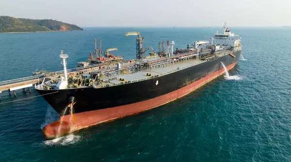 Tanker gemisi rafineri köprüsünden petrol boşaltıyor. Denizdeki petrol terminali rafinerisi, küresel iş ithalatı ve ihracat lojistik taşımacılık okyanus taşımacılığı, uluslararası konseptin kargo tankeri taşımacılığı, fotoğraf hava manzarası