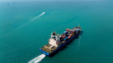 aerial view of large container ship sailing on deep sea, fully loaded with multi-colored containers, reflecting global business maritime transport cargo logistics, 