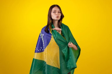 2022 Katar Kupası 'nda Brezilya futbol takımının resmi formasını giyen ve stüdyo fotoğrafında Brezilya bayrağı taşıyan bir kadın. Brezilyalı taraftar.