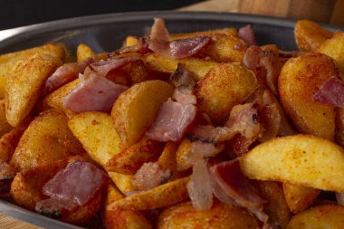 Biberli kızarmış patates ve ahşap bir tahtanın üstünde gümüş bir kasede domuz pastırması. Geleneksel Brezilya atıştırmalıkları