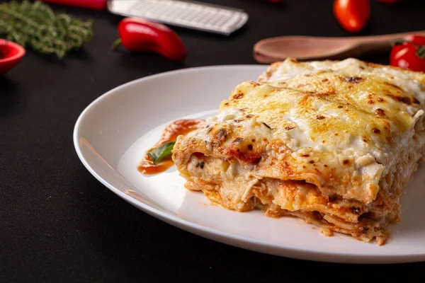 Lasagne Mit Geschmolzenem Käse Und Hühnerfleischfüllung Auf Einem Schwarzen Tisch — Stockfoto