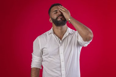 Adamım, sakallı, beyaz gömlekli, farklı yüz ifadeleri olan, kırmızı stüdyo arka planda.