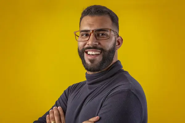 Sakallı, gözlüklü, siyah gömlekli, farklı yüz ifadeleri olan bir adam.