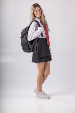 Klasik öğrenci kıyafeti, etek, kravat ve uzun kollu gömlek giyen, sonu gelmeyen bir geçmişi olan, komik pozlar veren genç bir kız..