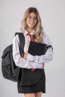 Klasik öğrenci kıyafeti, etek, kravat ve uzun kollu gömlek giyen, sonu gelmeyen bir geçmişi olan, komik pozlar veren genç bir kız..