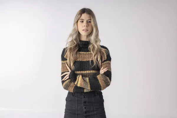 Stüdyo fotoğrafında bluz ve etek giyen genç bir kadın komik pozlar veriyor.