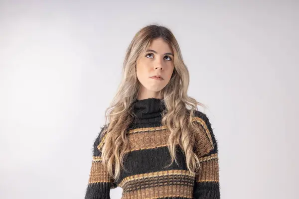 Stüdyo fotoğrafında bluz ve etek giyen genç bir kadın komik pozlar veriyor.