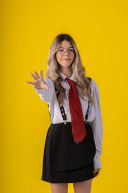 Klasik öğrenci kıyafeti, etek, kravat ve uzun kollu gömlek giyen, sonu gelmeyen bir geçmişi olan, komik pozlar veren genç bir kız..