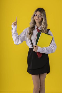 Klasik öğrenci kıyafeti, etek, kravat ve uzun kollu gömlek giyen, sonu gelmeyen bir geçmişi olan, komik pozlar veren genç bir kız..