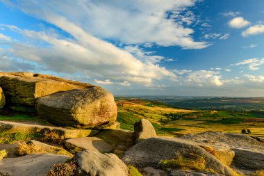 Millstones Stanage Edge ilkbaharda yeşil çimenler ve mavi gökyüzü