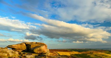 Millstones Stanage Edge ilkbaharda yeşil çimenler ve mavi gökyüzü