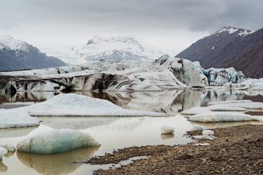İzlanda 'da bulutlu bir günde Heinabergjokull buzulu ve gölü