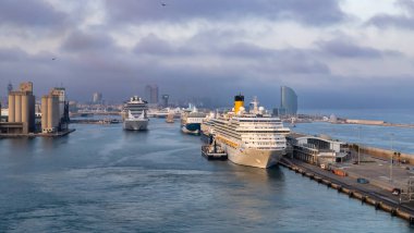 Barselona, İspanya - 28 Ekim 2022, Barselona limanında gün batımında ve bulutlu gökyüzünde seyir gemileri.