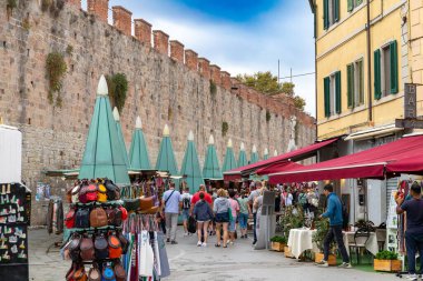 Pisa, İtalya - 24 Ekim 2022, Baptistery ve Camposanto Anıtı 'nın önünde hediyelik eşyalarla alışveriş caddesi.