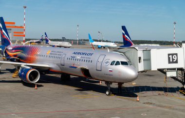 Moscow, Russia - July 12, 2021, Airplane of Russian airline Aeroflot near the terminal at an airport loading luggage, copy space