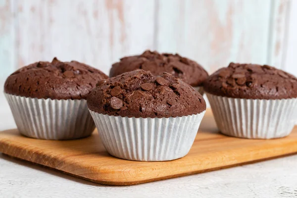 stock image Plain chocolate muffins with chocolate chips in white paper cups, close-up view, copy space