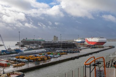 Southampton, İngiltere-4 Nisan 2024: Kargo gemisi Polaris Highway, bulutlu bir gökyüzünün altında inşaat araçları ve vinçlerle çevrili, hareketli bir endüstriyel limana yanaştı..