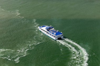 Portsmouth, İngiltere - 4 Nisan 2024: Yukarıdan yakalanan Wightlink feribotu, Portsmouth yakınlarındaki canlı yeşil sularda zarifçe gezinerek verimli bir deniz taşımacılığı olduğunu gösteriyor..
