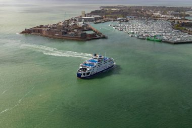 Portsmouth, İngiltere - 4 Nisan 2024: Wightlink feribotu hareket halindeki Portsmouth marinasına bakan, çeşitli teknelerle dolu yoğun limanı gösteren.