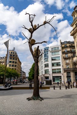 Paris, Fransa-14 Nisan 2025: Giuseppe Penone 'nin bronz heykeli Idee de Pierre, Paris plazasında dallarında büyük taşlar tutan yapraksız bir ağacı gösteriyor..