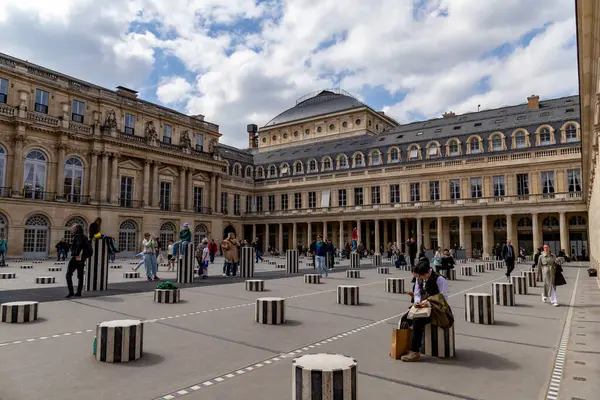 Paris, Fransa-14 Nisan 2025: Ziyaretçiler Daniel Buren 'in Palais-Royal avlusundaki sanat tesislerinin siyah-beyaz çizgili sütunlarını keşfedip etkileşime geçiyorlar.