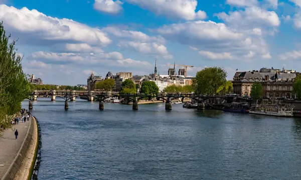 Paris, Fransa-14 Nisan 2025: Tarihi binaları, İnstitut de France kubbesi, güneşli bir bahar öğleden sonrasında ağaçlandırılmış kıyılar, botlar ve yayalar.