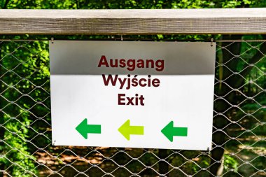 Heringsdorf, Mecklenburg-Batı Pomerania, Almanya - 29 Mayıs 2025: Ormanlık bir alanda çitli bir geçide monte edilmiş, solu işaret eden oklarla çıkış işareti.