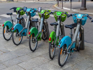 Paris, Fransa-14 Nisan 2025: Renkli kiralık motosikletler, Paris 'in orta kesimindeki bir sokak kenetlenme istasyonunda kolaylıkla ulaşılabilmesi için hizaya sokuldu.
