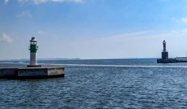 Aarhus, Danimarka-15 Ağustos 2025: Yeşil ve kırmızı çizgili iki küçük liman deniz feneri kılavuz gemileri, deniz ufku ve mavi gökyüzü arkaplanı.