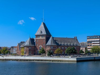 Aarhus, Danimarka-15 Ağustos 2025: Rıhtımda bulunan tarihi kırmızı tuğla bina Toldkammeret Eski Gümrük Dairesi, şimdi etkinlikler ve kültürel amaçlar için kullanılıyor.