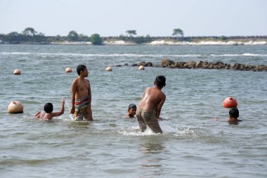 Jakarta, Indonesia on May 20,2024: Asian children are swimming at the edge of Ancol beach. defocused