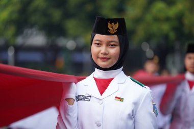 27 Mayıs 2024 'te Endonezya' nın Jakarta kenti: Endonezya Roundabout Oteli bölgesinde düzenlenen Pancasila etkinliğinde Endonezyalı kadın elinde uzun kırmızı ve beyaz bayrak tutuyor. Seçici odaklanma. Odaklanamadı