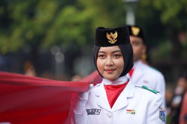 27 Mayıs 2024 'te Endonezya' nın Jakarta kenti: Endonezya Roundabout Oteli bölgesinde düzenlenen Pancasila etkinliğinde Endonezyalı kadın elinde uzun kırmızı ve beyaz bayrak tutuyor. Seçici odaklanma. Odaklanamadı