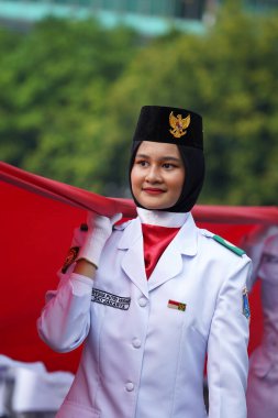 27 Mayıs 2024 'te Endonezya' nın Jakarta kenti: Endonezya Roundabout Oteli bölgesinde düzenlenen Pancasila etkinliğinde Endonezyalı kadın elinde uzun kırmızı ve beyaz bayrak tutuyor. Seçici odaklanma. Odaklanamadı