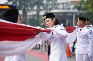 27 Mayıs 2024 'te Endonezya' nın Jakarta kenti: Endonezya Roundabout Oteli bölgesinde düzenlenen Pancasila etkinliğinde Endonezyalı kadın elinde uzun kırmızı ve beyaz bayrak tutuyor. Seçici odaklanma. Odaklanamadı