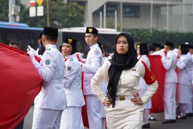 27 Mayıs 2024 'te Endonezya' nın Jakarta kenti: Endonezya Roundabout Oteli bölgesinde düzenlenen Pancasila etkinliğinde Endonezyalı kadın elinde uzun kırmızı ve beyaz bayrak tutuyor. Seçici odaklanma. Odaklanamadı