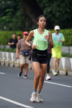 9 Haziran 2024 'te Endonezya' nın Jakarta kenti: Sudirman - Thamrin, Merkez Jakarta 'da sabah saatlerinde Arabasız Günü' nde egzersiz yapan Asyalı insanlar. Seçici odaklanma. Odaklanamadı